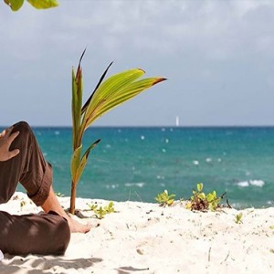 Constance Lemuria - Luxury Seychelles Honeymoon Packages - couple relaxing on beach