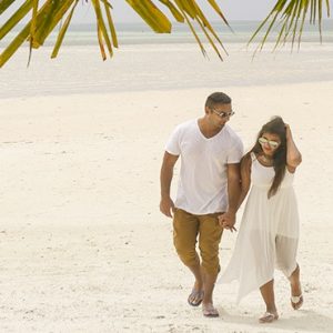 Maldives Honeymoon Packages Medhufushi Island Resort Couple Strolling On Beach
