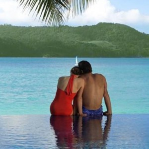 Beach Club Hamilton Islands - Australia Honeymoon Packages - couple sitting on the edge of beach club pool