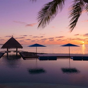 Four Seasons Resort Maldives at Kuda Huraa - Maldives Honeymoon Packages - pool at sunset