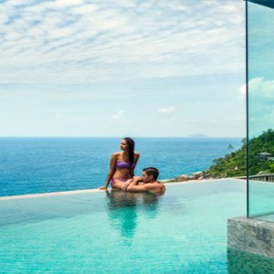 Four Seasons Resort Seychelles - Luxury Seychelles Honeymoon packages - couple in pool ocean gazing