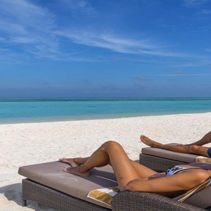 Cocoon Maldives - Luxury Maldives Honeymoon Packages - relaxing on the beach