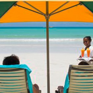 Acajou Beach Resort - Luxury Seychelles Honeymoon Packages - Couple relaxing on the beach