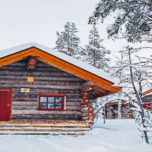 Kakslauttanen Arctic Resort - Luxury Finland Honeymoon Packages - Log Cabins exterior in snow