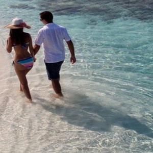 Coco Bodu Hithi - Luxury Maldives Honeymoon Packages - Couple on beach