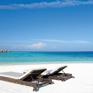 Constance Moofushi - Luxury Maldives Honeymoon Packages - Sun loungers on beach