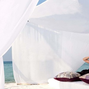 Constance Moofushi - Luxury Maldives Honeymoon Packages - Woman relaxing on beach