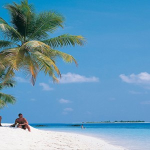 Diamonds Athuruga - Luxury Maldives Honeymoon Packages - couple on beach