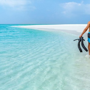 Hurawalhi Island - Luxury Maldives Honeymoon Packages - couple on beach snorkelling