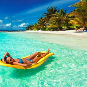 Lily Beach Resort and Spa at Huvahendhoo - Luxury Maldives Honeymoon Packages - Beach Villa women in ocean