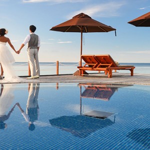 Lily Beach Resort and Spa at Huvahendhoo - Luxury Maldives Honeymoon Packages - wedding couple by pool