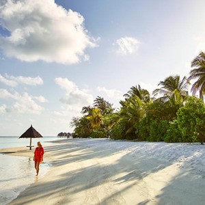 Lux South Ari Atoll - Luxury Maldives Honeymoon Packages - Woman taking a stroll on beach