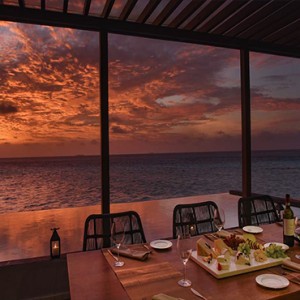 Ozen by Atmosphere at Maadhoo Island - Luxury Maldives Honeymoon Packages - OZEN Water suite exterior dining at sunset