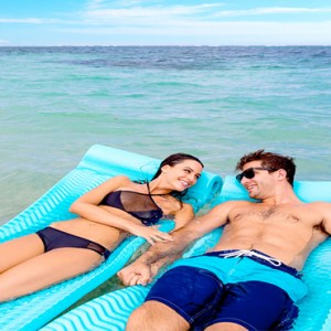 Serenity at Coconut Bay - Luxury St lucia Honeymoon Packages - Couple floating in sea