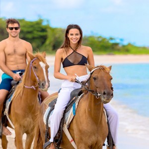 Serenity at Coconut Bay - Luxury St lucia Honeymoon Packages - Couple horse riding on beach