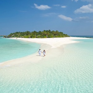 Sun Aqua Vilu Reef - Luxury Maldives honeymoon packages - couple strolling on Sandbank