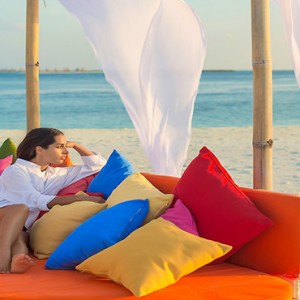 Sun Aqua Vilu Reef - Luxury Maldives honeymoon packages - woman relaxing on the beach