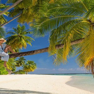 Sun Aqua Vilu Reef - Luxury Maldives honeymoon packages - women on tree on beach