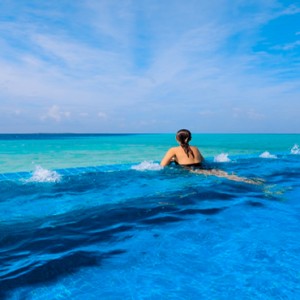 Velassaru Maldives - Luxury Maldives Honeymoon Packages - woman in main infinity pool